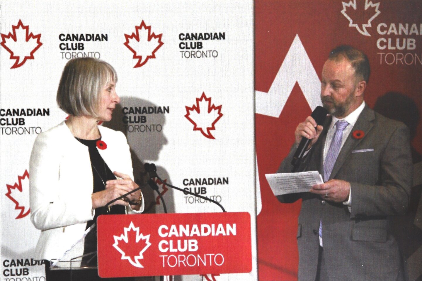 Michael Bach speaking with another presenter at a Canadian Club Toronto event